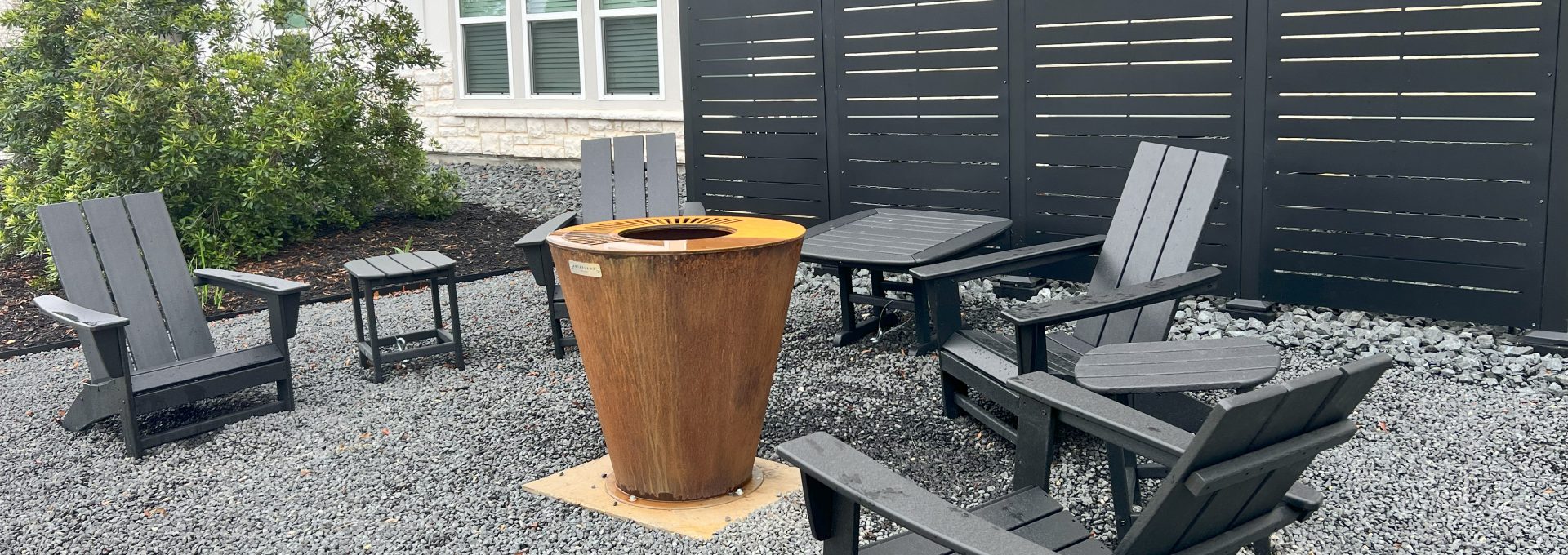 a patio with chairs and a fire pit at The Garden Creek Apartments
